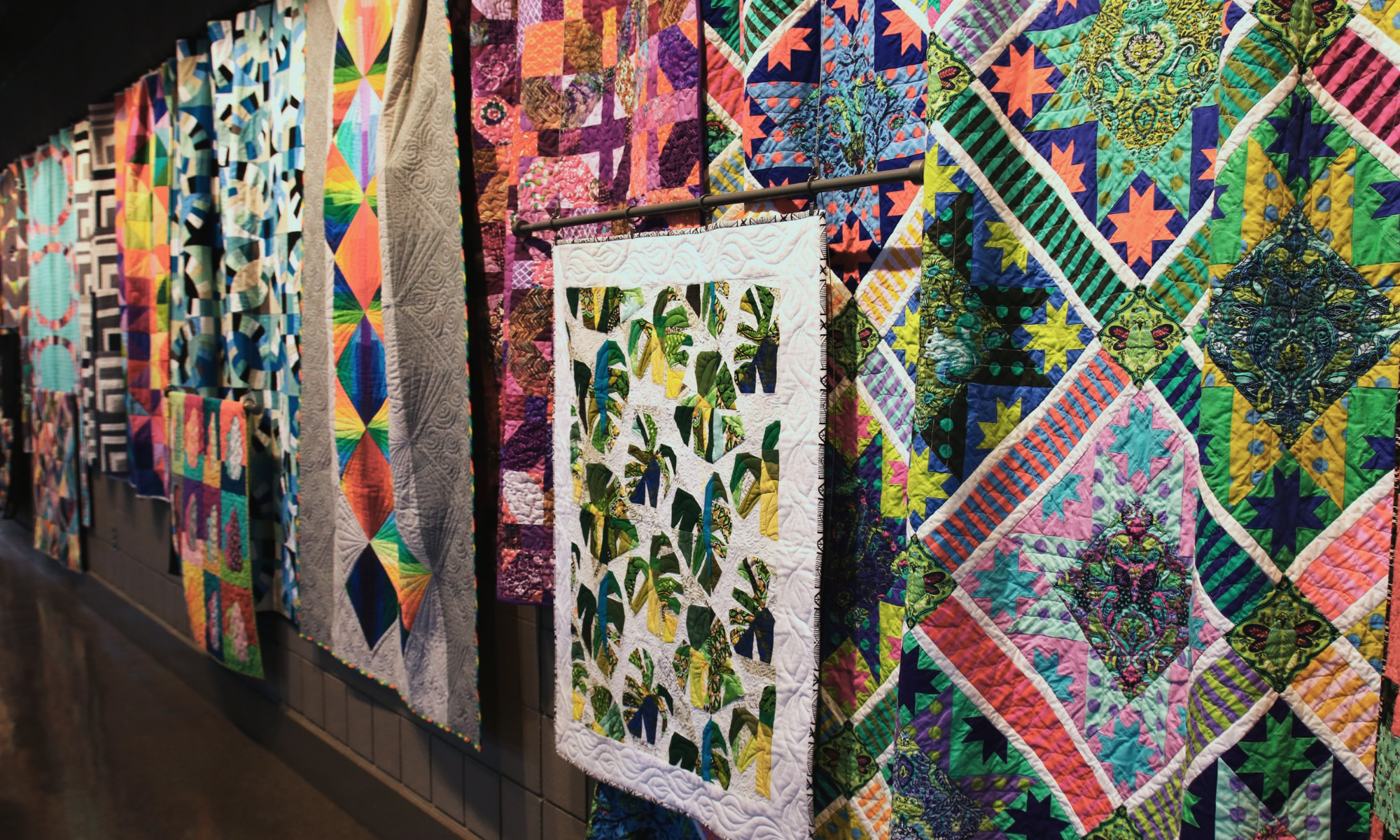 quilts hung on an art gallery wall